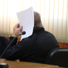 Primer pla de l'acusat tapant-se la cara amb un full de paper a la sala de vistes de l'Audiència de Tarragona.