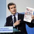 El vicesecretario de comunicación del PP, Pablo Casado, muestra un cartel de Cerca en la rueda de prensa del 18 de septiembre del 2017.