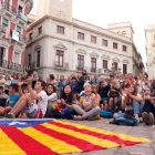 Una estelada estirada a terra davant dels ciutadans que segueixen des de la plaça del Mercadal de Reus la compareixença del president Carles Puigdemont.