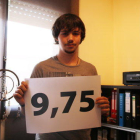 Pla mig d'Arnau Dols mostrant un cartell amb la seva nota de la selectivitat, al despatx de casa seva.