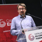 El jefe de filas de los comunes en el Parlament, Xavier Domènech, con el logo del partido de fondo.