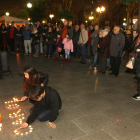 Un nen i una nena encenen espelmes al lloc on la Carolina va morir el passat 9 de febrer.