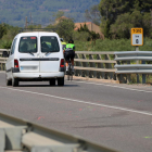 Pla general del punt quilomètric 8 de la T-310 entre Riudoms i Montbrió, amb un grup de ciclistes circulant mentre un cotxe els intenta avançar hores després d'un accident mortal amb dos ciclistes en el mateix punt.