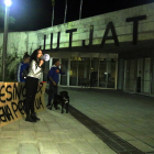 Quatre persones escridassen el detingut pel crim de la nena de Vilanova i la Geltrú des de fora els jutjats, amb una pancarta.