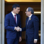 El president de la Generalitat, Quim Torra, i el president del govern espanyol, Pedro Sánchez, encaixen les mans a les portes del palau de la Moncloa.