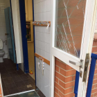 Imagen de una de las puertas con los cristales rotos a la Escola Cèsar August.