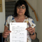 Maria Rosa Piñol amb el formulari de danys que reparteix l'Ajuntament de Flix per inventariar els desperfectes del foc.
