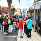 Plano general de la cola de personas esperando subir a los buses organizados por la ANC en Amposta.