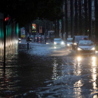 Varios coches circulan esta mañana por la calle Plano de San Francisco de Murcia, inundada tras las intensas lluvias caídas esta madrugada.