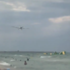 Imagen del avión sobrevolando a los bañistas en la playa de Calafell.