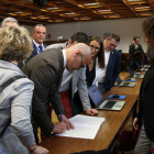 El senador electo de ERC Raül Romeva firmante un documento durante el trámite de recogida del acta de senador acompañado de otros senadores republicanos.