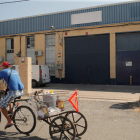Un hombre pasa en una bicicleta cerca de la fábrica Magrudis en Sevilla, foco del brote de listeriosis.