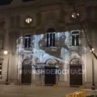 Imatge de la façana del Tribunal Suprem en què es projecta un vídeo de càrregues policials durant l'1-O.