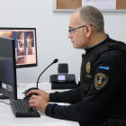 Plano medio de un agente de la Policía Local de Calafell supervisando el puesto de control de video vigilancia.