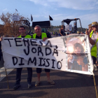 Pla general d'un grup de manifestants afectats pels focs del juny mostrant una pancarta que demana la dimissió de la consellera Teresa Jordà, el 18 d'agost del 2019 (horitzontal)