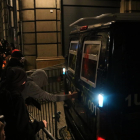 Un noi intenta obrir la furgoneta policial al carrer de les Magdalenes amb Via Laietana amb pintades i pintura.