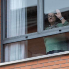 Una mujer saluda desde una residencia