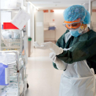 Una professional sanitària de l'Hospital Clínic es prepara per atendre un pacient amb covid-19, en un dels blocs quirúrgics habilitat com a UCI