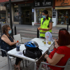 Una educadora informant a dues dones assegudes a una terrassa d'un bar de Reus.