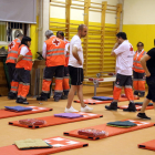 Plan|Plano general del aula deportiva de la escuela Enric Grau Fontseré de Flix con los voluntarios de Cruz Roja preparando todos los colchones y mantas para dormir los desalojados. Imagen del 27 de junio del 2019 (horizontal)