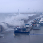 Pla general de les onades sobrepassant el moll pesquer del port de l'Ampolla.