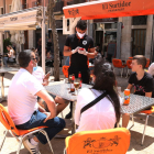 Plano abierto de un camarero anotando la comada a unos clientes en una terraza de la plaza de la Font de Tarragona en el primer sábado de la fase 1.