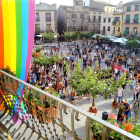 La plaza Major de Prades llena de personas concentradas contra la homofobia, con la bandera LGTBI colgada en primer término en el Ayuntamiento.