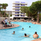 Pla general de turistes banyant-se i prenent el sol en una piscina de l'hotel Golden Port Salou & Spa