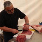 Un home tallant una peça de tonyina