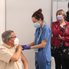 La consellera de Salut, Alba Vergés, mirando como administran una vacuna a un hombre al punto de vacunación masiva del Palau d'Esports Catalunya de Tarragona.