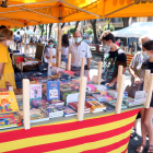 Una puesto de libros en la Rambla Nova de Tarragona con varios clientes.
