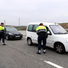 Dos agentes requiriendo la documentación a conductores parados en el control policial de la T-11 en Tarragona.