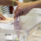 Imatge d'arxiu d'una persona dipositant el seu vot en una urna.