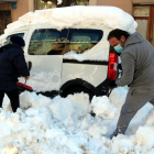 Dos vecinos de Falset desenterrando su vehículo, enterrado por la nieve.