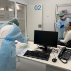 Dos persones fent una prova PCR a un pacient a l'espai hospitalari polivalent de l'Arnau de Vilanova de Lleida.