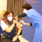 Una agente de los Mossos d'Esquadra recibiendo una dosis de la vacuna de AstraZeneca.