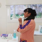 Una docente del Jardín de Infancia Sant Ramon Nonat de Gerona se toma una muestra de tejido por frotis nasal.