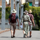 Plano abierto con tres turistas con la cabeza cubierta con sombreros en Lleida.