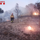 Un bombero en medio de un paraje quemado durante un incendio