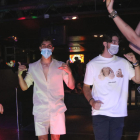 Un grupo de jóvenes con mascarilla baila en el interior de una una discoteca.