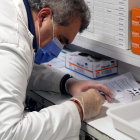 Plano corto de un farmacéutico analizando una muestra de un test de antígenos.