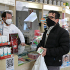 Un usuari comprant tres tests d'antígens en una farmàcia.