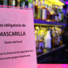 Detalle de un cartel en un bar musical indicando a los clientes el uso obligatorio de mascarilla dentro del establecimiento.