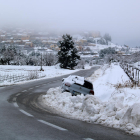 Paisatge nevat a Horta de Sant Joan amb un vehicle que ha sortit de la via a l'entrada al poble.