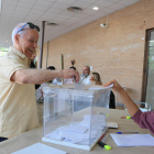 Un home diposita el seu vot en una de les meses constituïdes al Palau Firal de Tarragona.