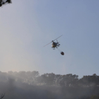 Un helicóptero de los Bomberos de la Generalitat, desde La Pobla de Montornès, durante los trabajos de extinción del incendio forestal de Vespella de Gaià.