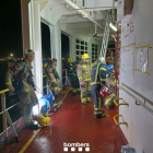 Imatge dels bombers treballant per apagar l'incendi al vaixell.