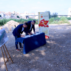 El president del Consell del Baix Ebre, Antoni Gilabert, i l'alcalde de l'Aldea, Xavier Royo, signen la cessió dels terrenys amb el pont penjant d'Amposta i el tram de l'enllaç de la via verda, al fons.