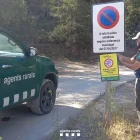 Un Agent Rural col·loca un cartell de prohibició de circulació per perill d'incendi forestal