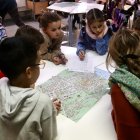 Imatge d'arxiu d'un grup d'alumnes de l'escola de la Draga que miren en el mapa com crear un itinerari per fer amb la classe